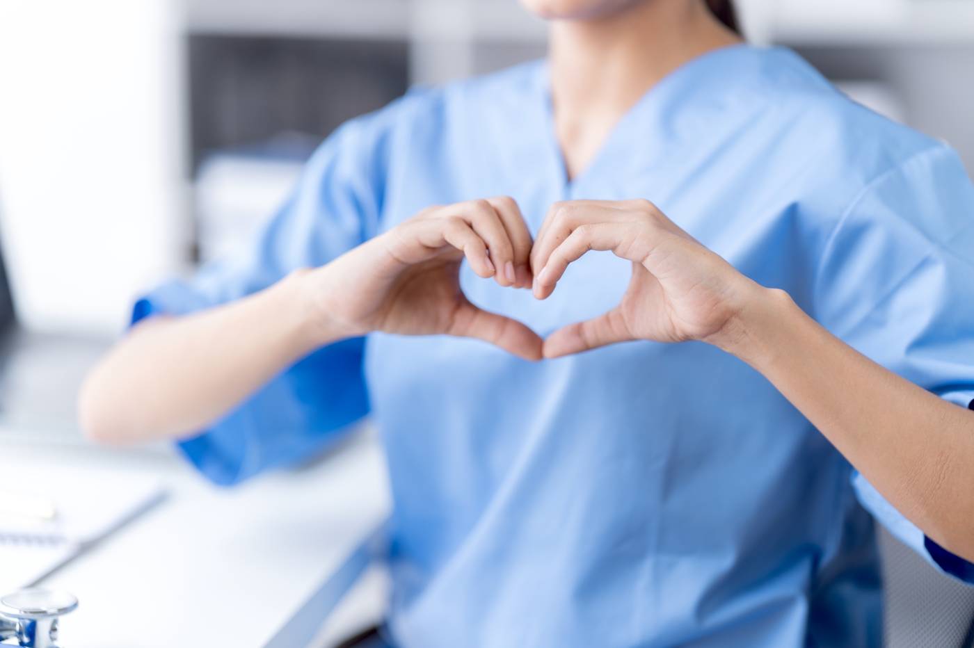Female nurse using hands to gesture a heart shape