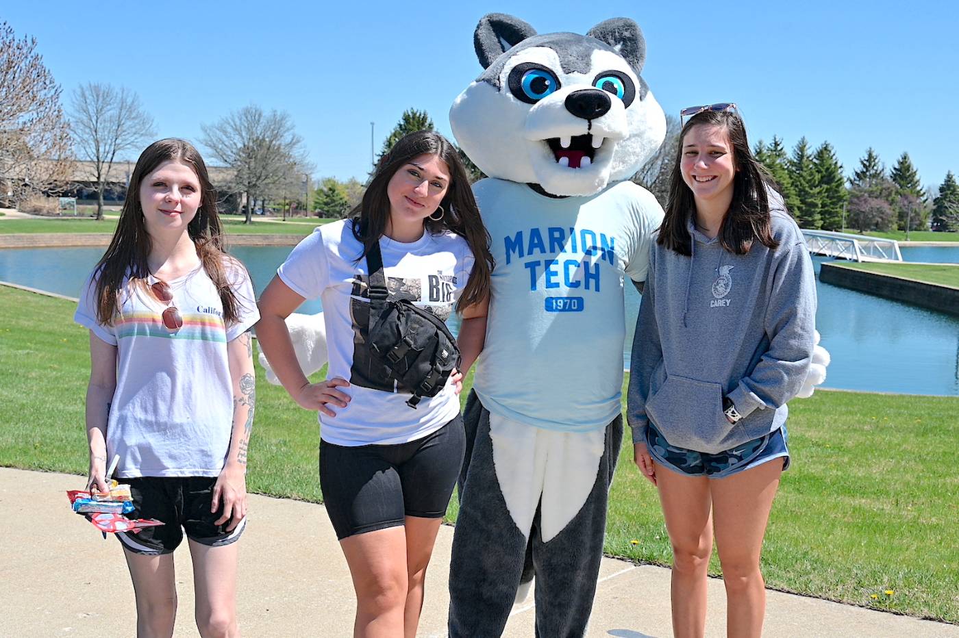 Students standing on campus with mascot
