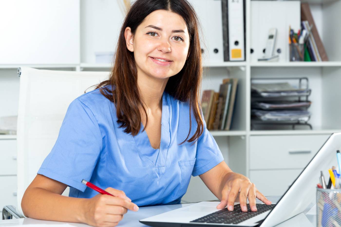 Female healthcare manager working on laptop at desk